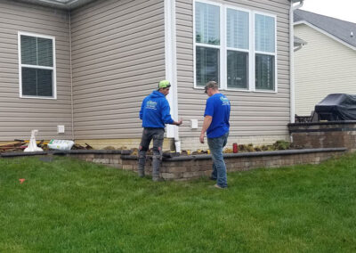 quality yard crew working on retaining wall