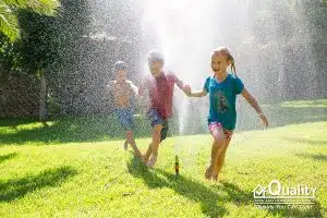 Children running through the sprinkler in summertime. Classic!
