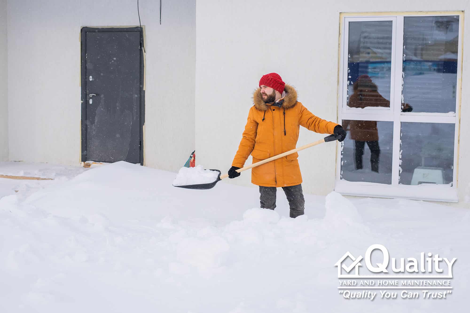 Quality Yard & Home Maintenance shoveling snow on residential sidewalk