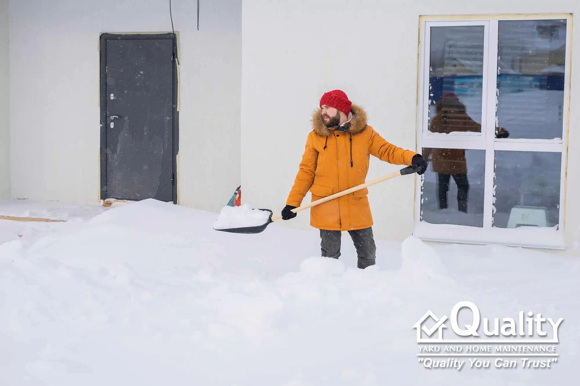 Quality Yard & Home Maintenance shoveling snow on residential sidewalk