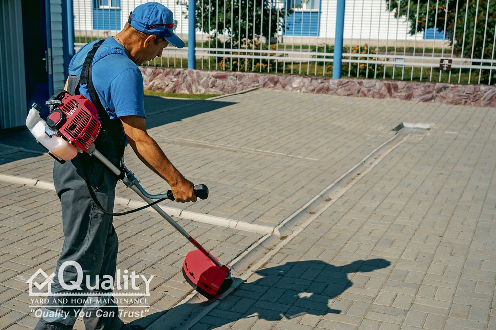 Quality Yard & Home Maintenance team trimming a sidewalk